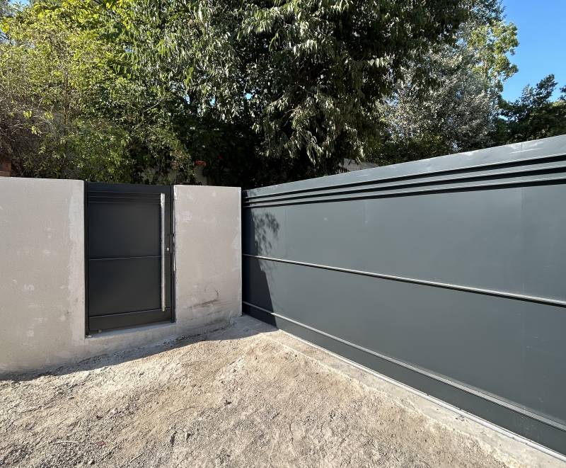 Portail coulissant en acier thermolaqué au Prado, Marseille. Motorisation Camé AGS, portillon assorti avec finition inox. Élégance et robustesse garanties.