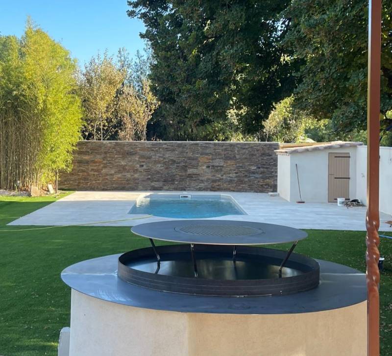 Fabrication sur mesure d’un brasero en acier avec plaque inox et comptoir intégré pour une villa à Aubagne – Convivialité et savoir-faire par Métallerie du Midi